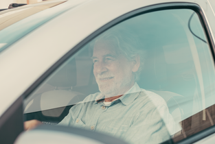 Ubezpieczenie samochodu dla seniora - starszy mężczyzna prowadzący samochód
