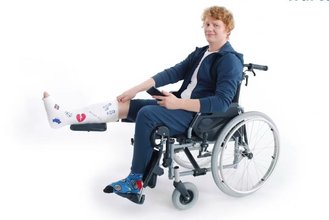 Mężczyzna ze złamaną nogą siedzący na wózku inwalidzkim