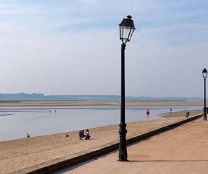 Uszkodzona lampa zewnętrzna, a w tle plaża