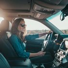 Kobieta w niebieskiej koszulce jadąca samochodem, która ma wykupione AC w Warcie 