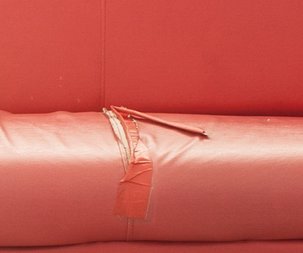 Czerwona sofa - zbliżenie na uszkodzenie