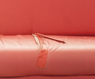 Uszkodzenie czerwonej kanapy Czerwona sofa - zbliżenie na uszkodzenie