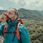 Mężczyzna w górach zażywający lek wziewny na astmę, ubezpieczony w Warcie - Warta Travel 