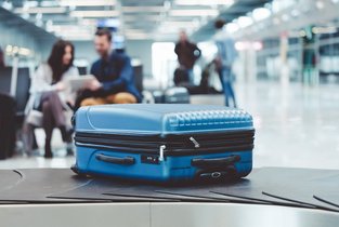 Niebieska walizka symbolizująca ubezpieczenie turystyczne w Warcie 