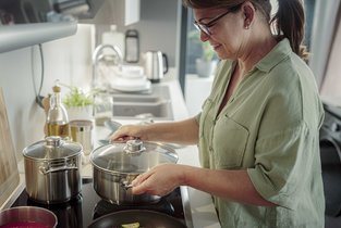 Kobieta gotuje obiad na płycie indukcyjnej