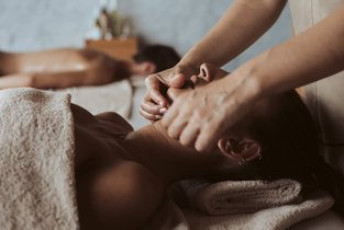 Kobieta relaksująca się w studio masażu, gdzie właściciel ubezpieczył swój biznes w Warcie 