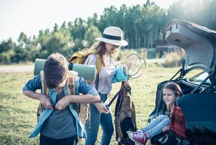 Kobieta z dziećmi przy samochodzie 