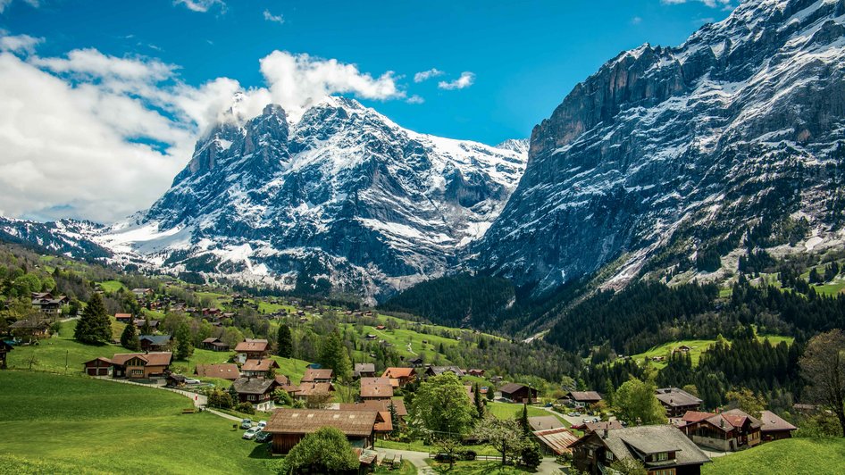 Wioska Grindelwald w Szwajcarii otoczona alpejskimi szczytami, z widoczną górą Wetterhorn w tle