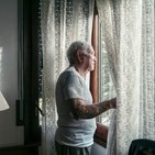 Starszy mężczyzna w białej koszulce przy oknie 