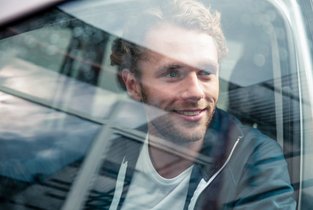 Szczęśliwy mężczyzna po założeniu profilu kierowcy i zdaniu egzaminu