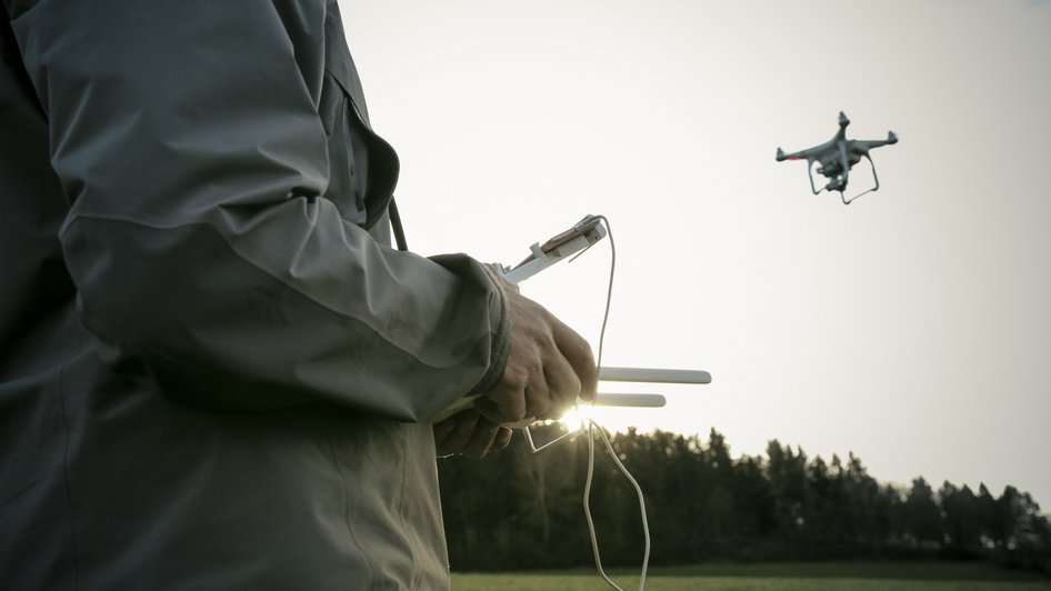 Mężczyzna steruje dronem - ma kupione ubezpieczenie drona OC