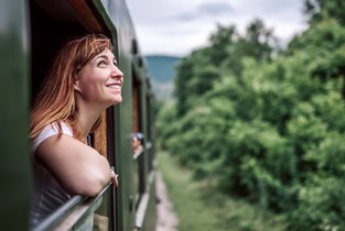 Kobieta podróżuje pociągiem po Europie i podziwia widoki
