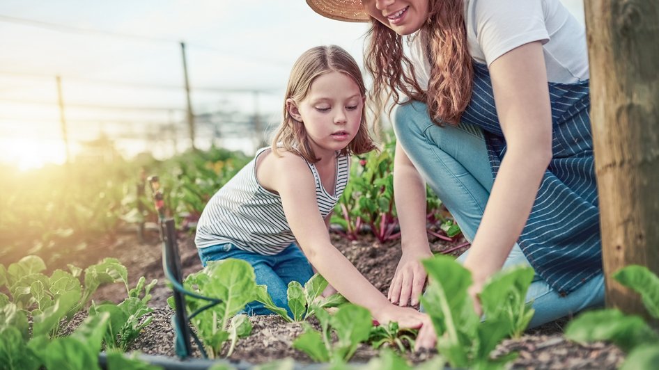 Mama i córka pracują spokojnie w ogrodzie, ponieważ wiedzą, jak postępować z raną zabrudzoną ziemią.