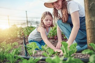 Mama i córka pracują spokojnie w ogrodzie, ponieważ wiedzą, jak postępować z raną zabrudzoną ziemią.