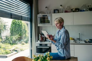 Kobieta sprawdza online świadectwo energetyczne mieszkania.