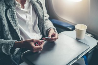 Kobieta w podróży przewozi leki w samolocie, które przyjmuje regularnie.