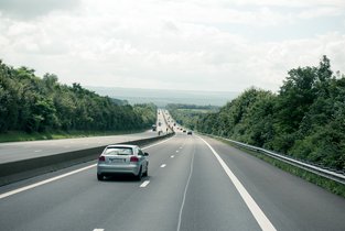 Samochód jadący dwupasmową drogą - ograniczenia prędkości w Polsce