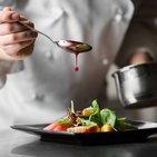 Szef kuchni przygotowywuje danie w swojej restauracji, która jest ubezpieczona w Warcie 