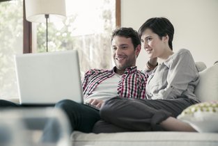 Kobieta i mężczyzna wyceniają mieszkanie do ubezpieczenia online.