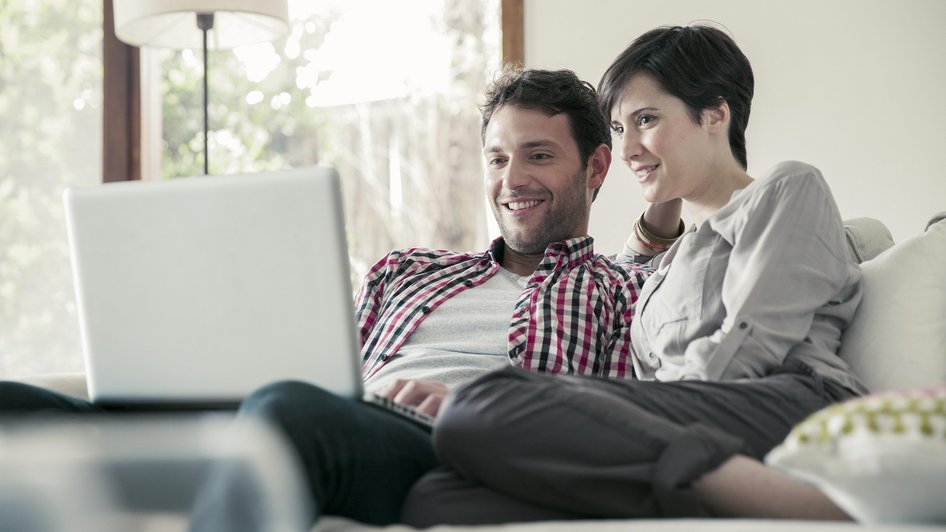 Kobieta i mężczyzna wyceniają mieszkanie do ubezpieczenia online.