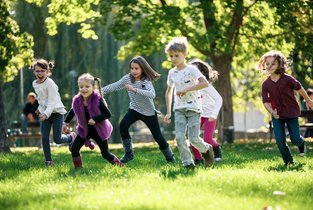 Dzieci biegają po trawie 