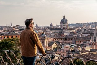 Mężczyzna wybrał się na citybreak do Rzymu i podziwia piękną panoramę miasta.