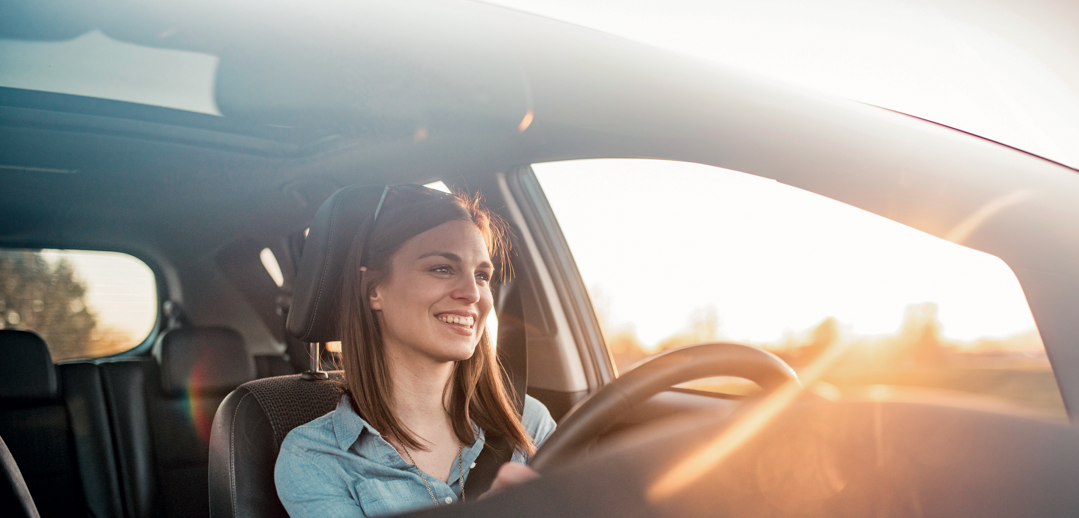 Uśmiechnięta kobieta jedzie przerejestrować swoje auto Uśmiechnięta kobieta jadąca autem