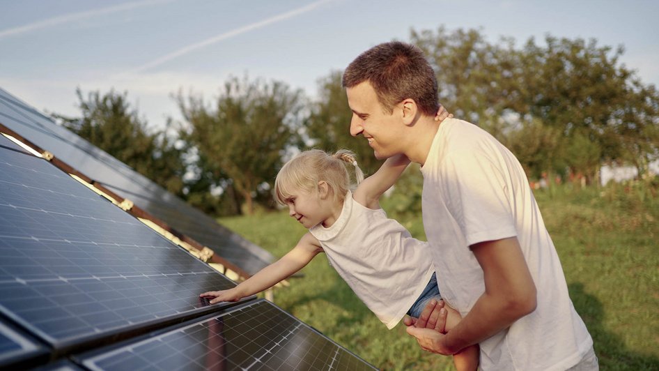 Tata z córką przy panelach fotowoltaicznych 