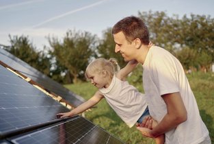 Tata z córką przy panelach fotowoltaicznych 