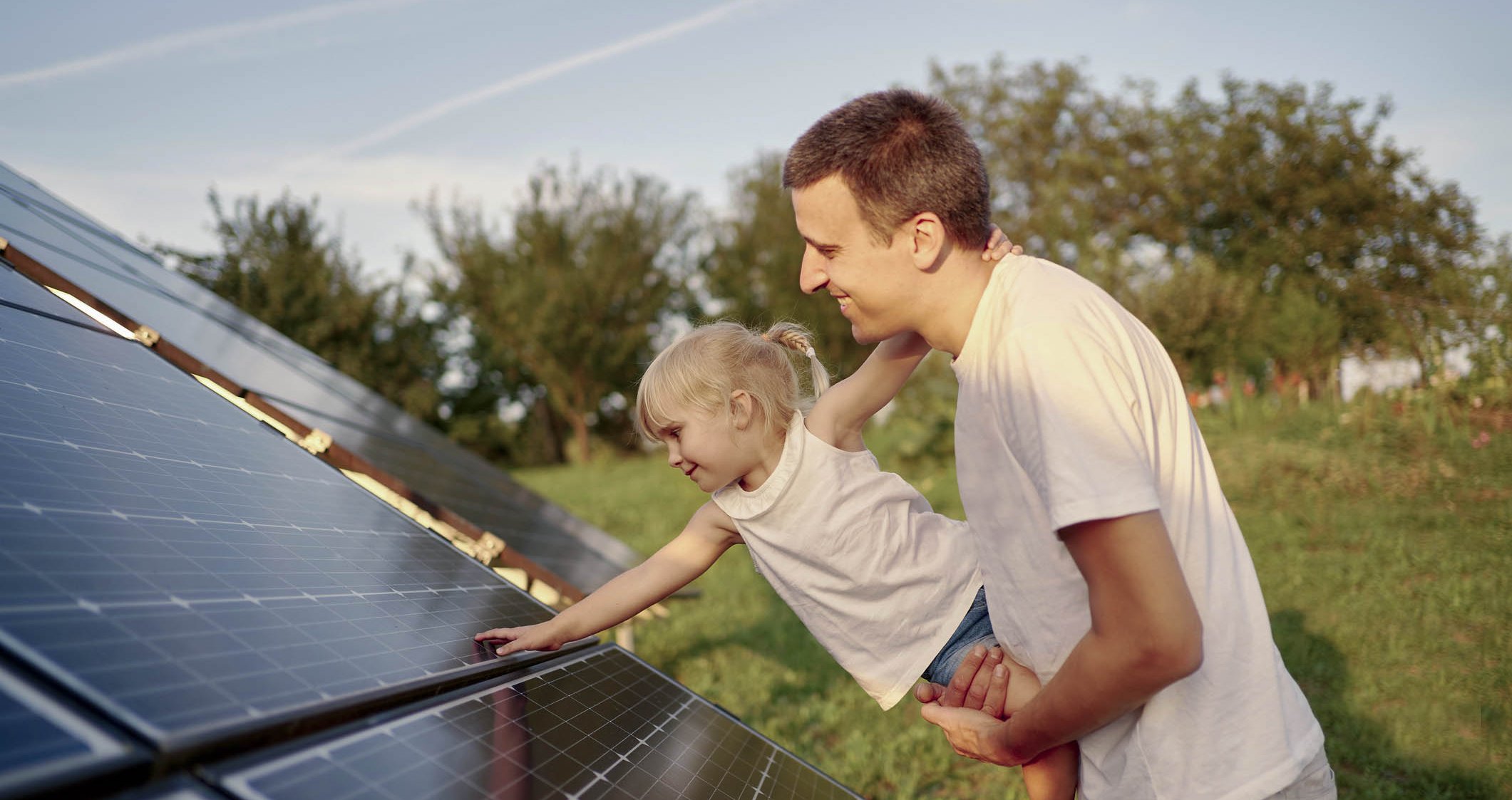 Tata z córką przy panelach fotowoltaicznych 