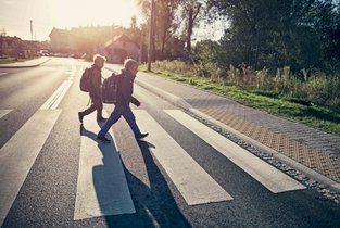 Dzieci idące przez ulicę, które dobrze znają zasady zachowania na przejściu dla pieszych