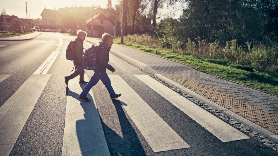 Dzieci idące przez ulicę, które dobrze znają zasady zachowania na przejściu dla pieszych