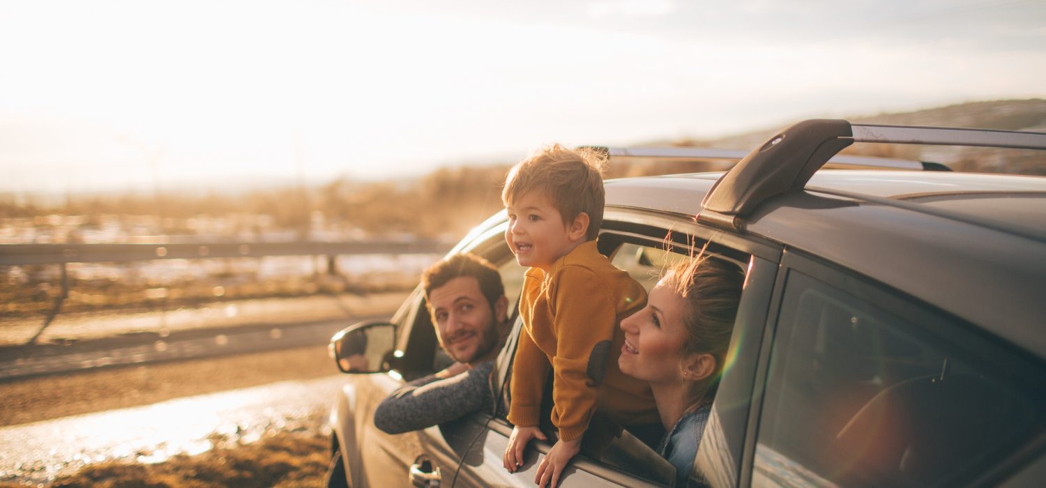 Rodzina z dzieckiem ogląda piękne krajobrazy siedząc w samochodzie ubezpieczonym w Warcie