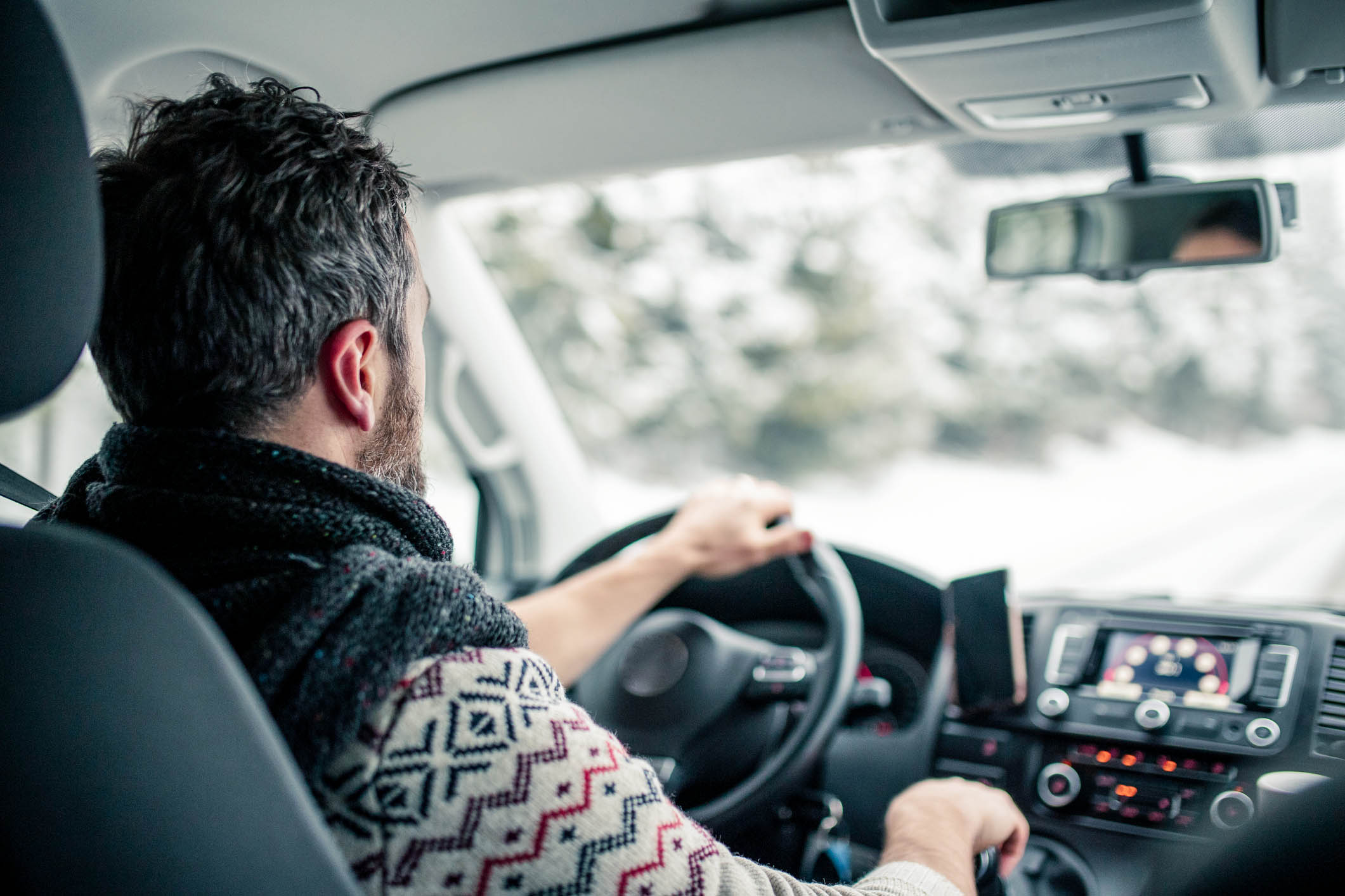 Mężczyzna prowadzący samochód zimą 