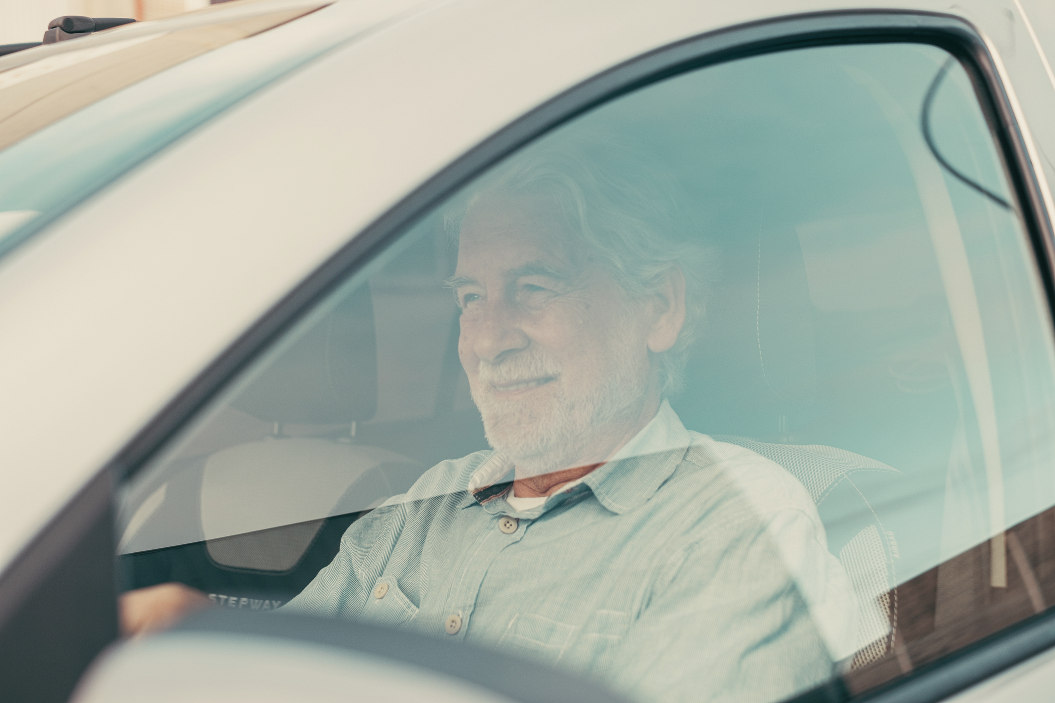 Ubezpieczenie samochodu dla seniora - starszy mężczyzna prowadzący samochód