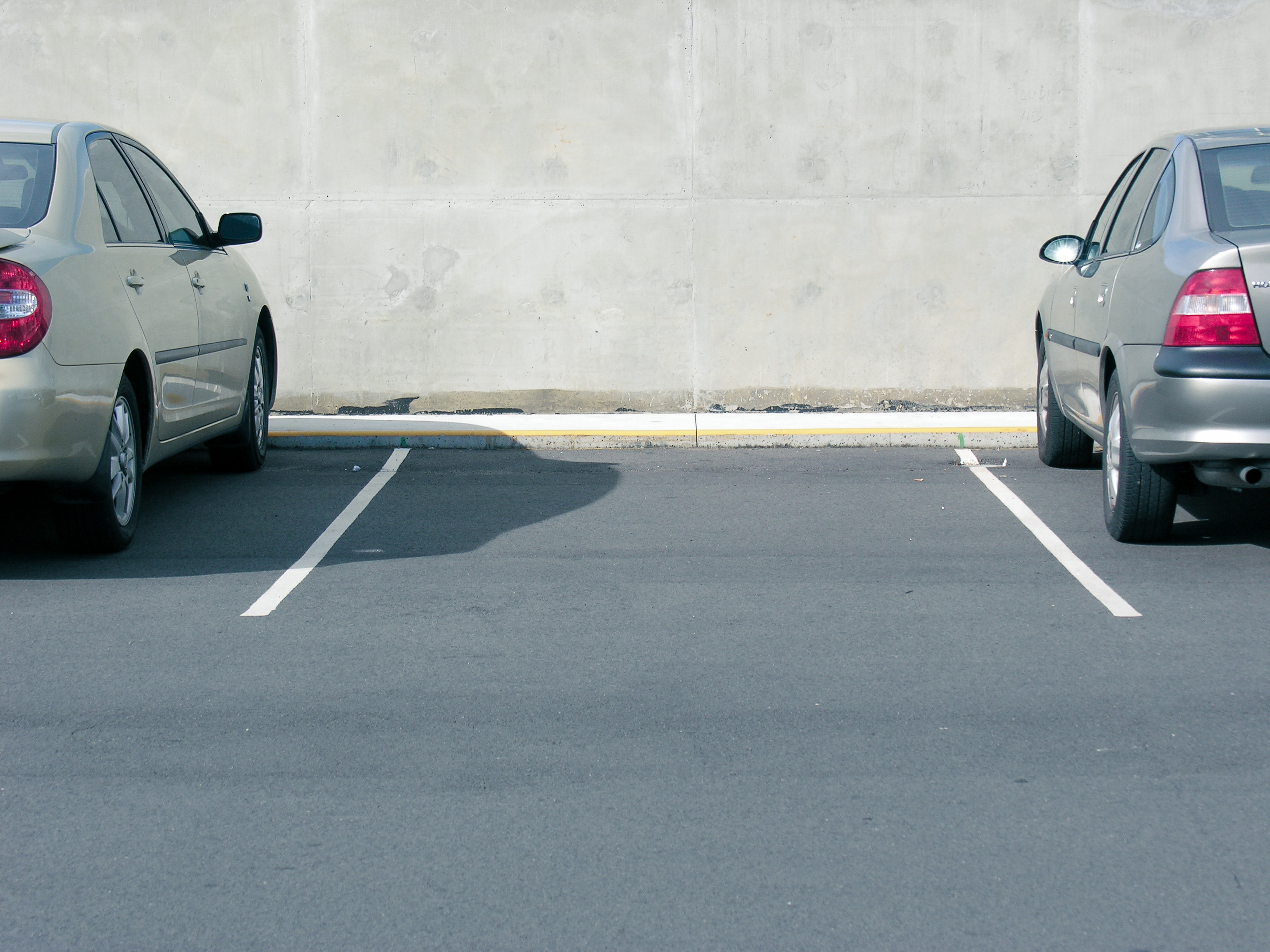 Dwa samochody stojące na parkingu, które są ubezpieczenie na wypadek kradzieży 