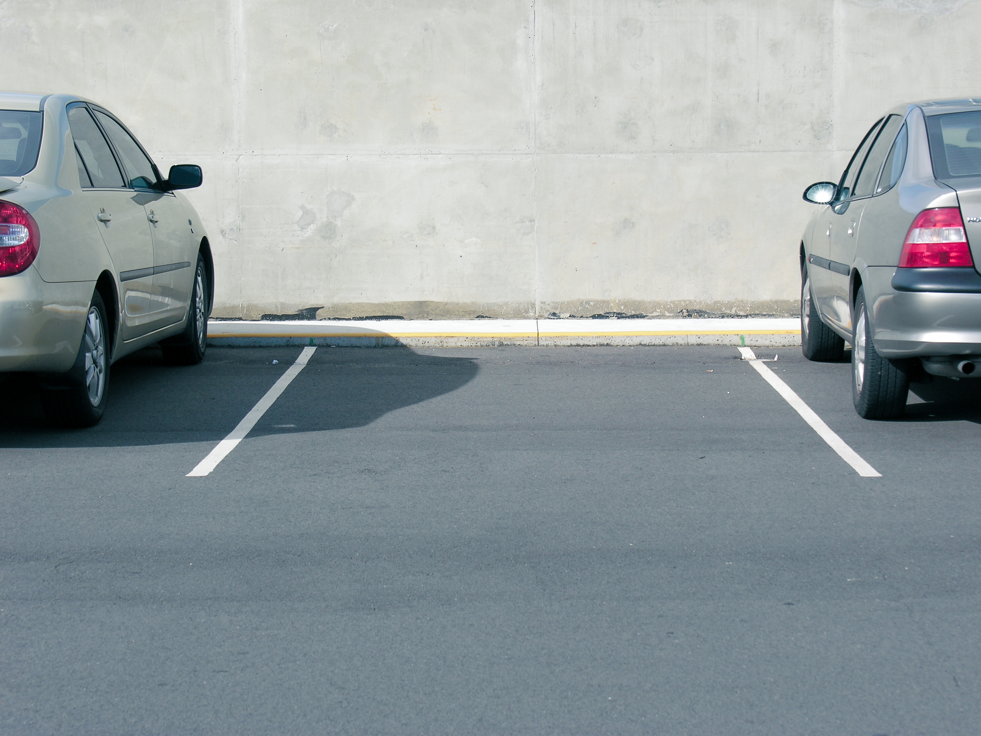 Ubezpieczenie AC - kradzież auta Dwa samochody stojące na parkingu, które są ubezpieczenie na wypadek kradzieży