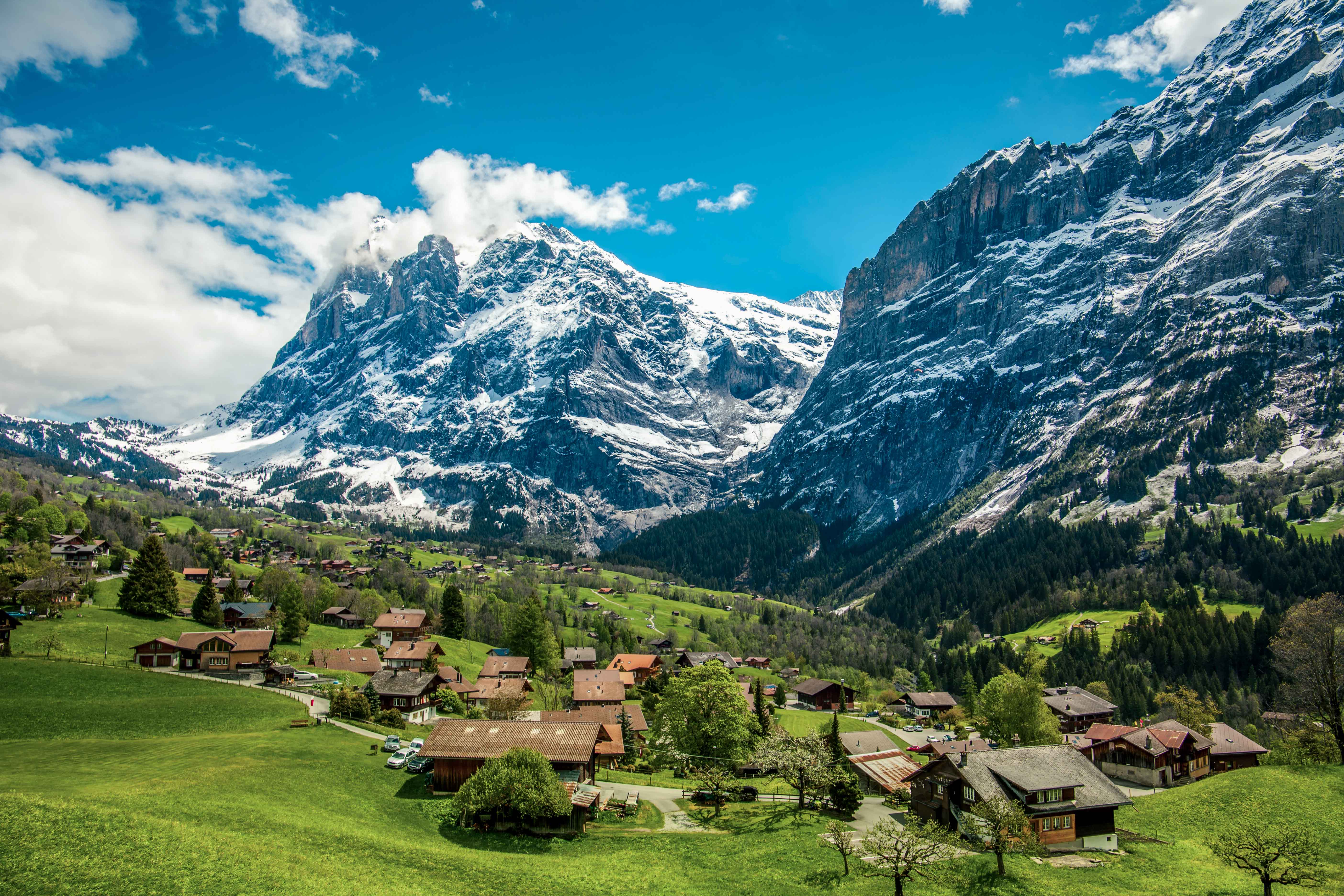 Wioska Grindelwald w Szwajcarii otoczona alpejskimi szczytami, z widoczną górą Wetterhorn w tle