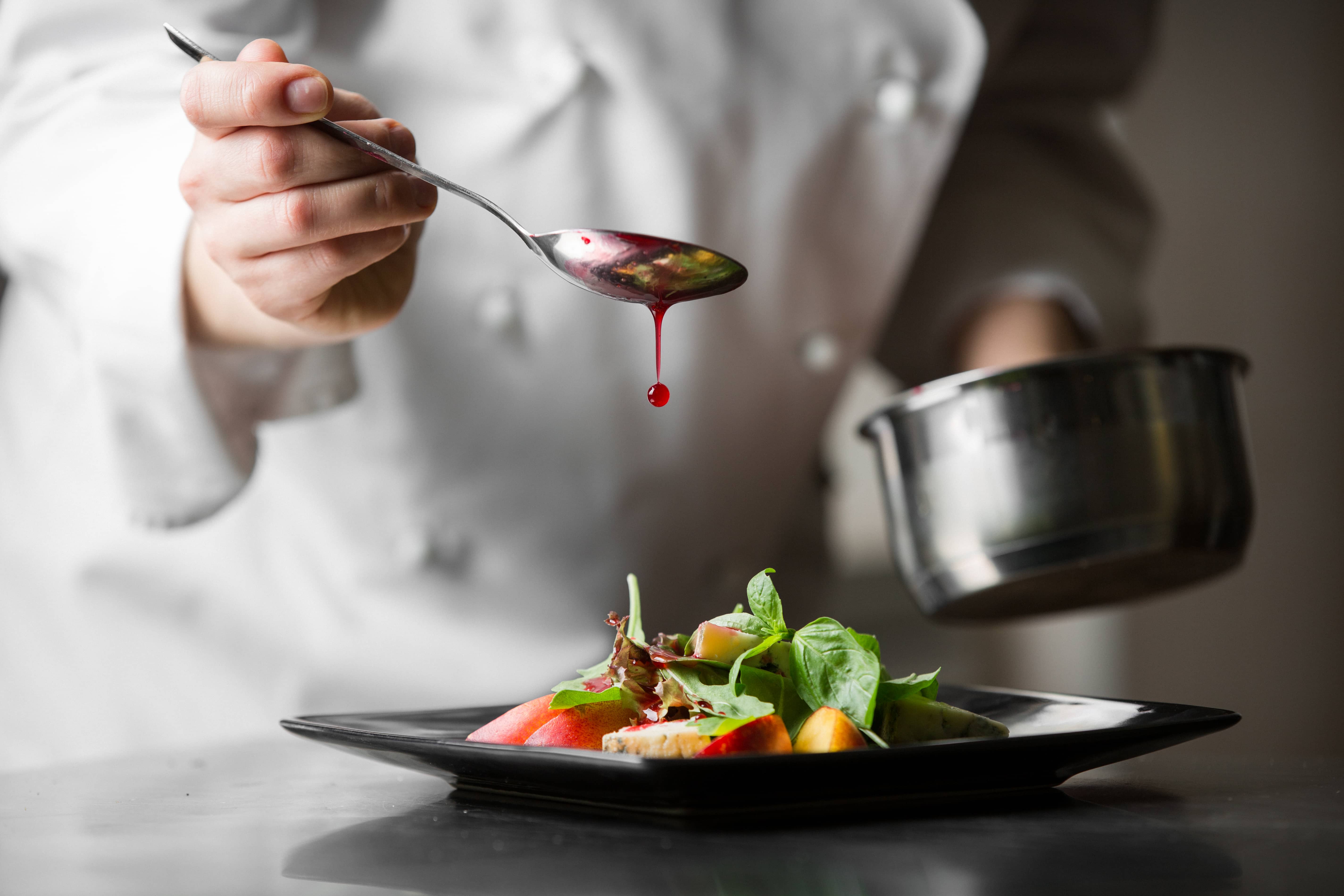 Szef kuchni przygotowywuje danie w swojej restauracji, która jest ubezpieczona w Warcie 